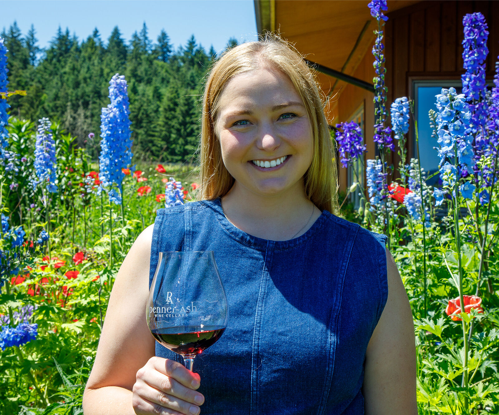 Haley Vachter in Penner-Ash garden with a glass of red wine.